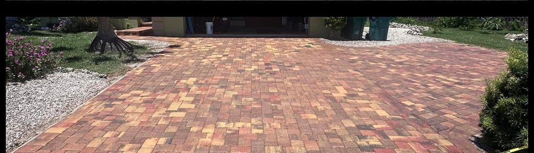 After: the same driveway stripped of its failed sealer, re-sanded and sealed to a deep even red, in Bonita Springs, FL — Gulf Coast Sealing & Pressure Cleaning