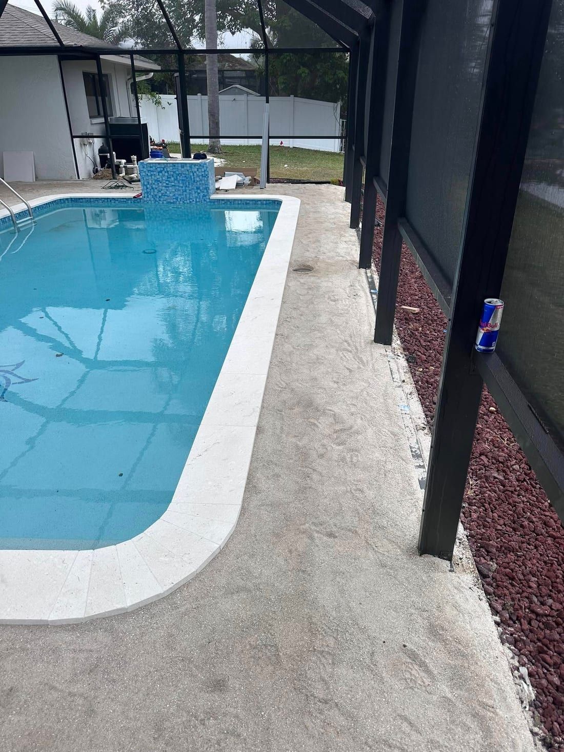 Before: the old worn pool deck inside the screen cage, before a travertine installation in Southwest Florida — Gulf Coast Sealing & Pressure Cleaning