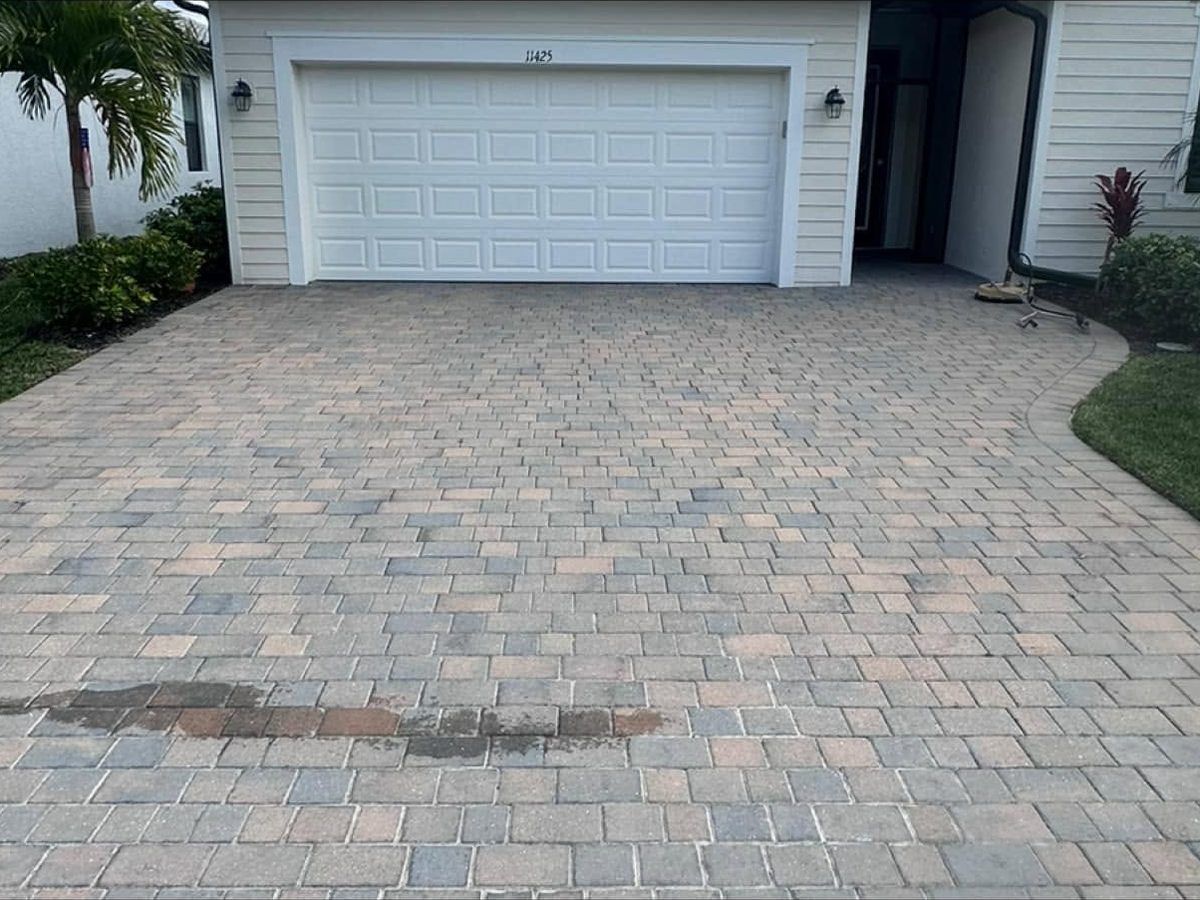Before: stained, faded paver driveway before cleaning and sealing in Bonita Springs, FL — Gulf Coast Sealing & Pressure Cleaning