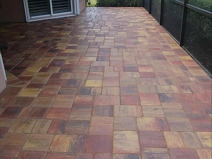 After: the same lanai pavers sealed to a rich red and gold wet-look finish in Naples, FL — Gulf Coast Sealing & Pressure Cleaning