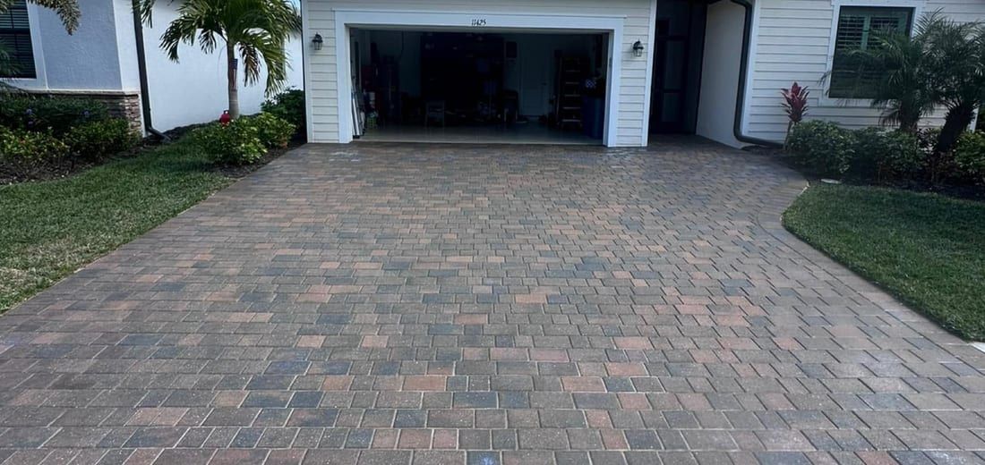 After: the same driveway cleaned, re-sanded and sealed to a deep even color in Southwest Florida — Gulf Coast Sealing & Pressure Cleaning