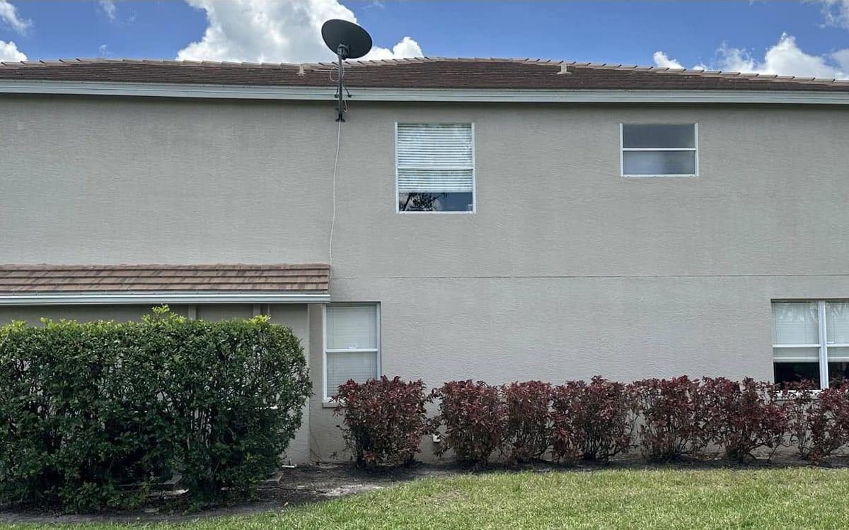 Two-storey stucco home after a soft house wash removed the algae streaks in Bonita Springs, FL — Gulf Coast Sealing & Pressure Cleaning