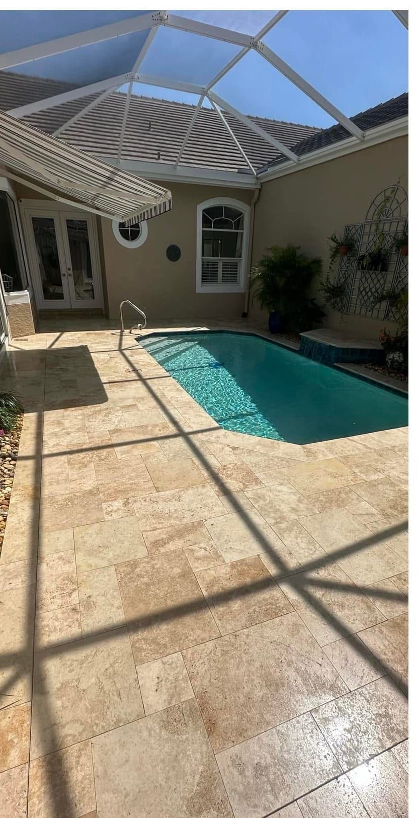 Travertine pool deck sealed with an enhancing sealer that deepens the stone color, in Southwest Florida — Gulf Coast Sealing & Pressure Cleaning